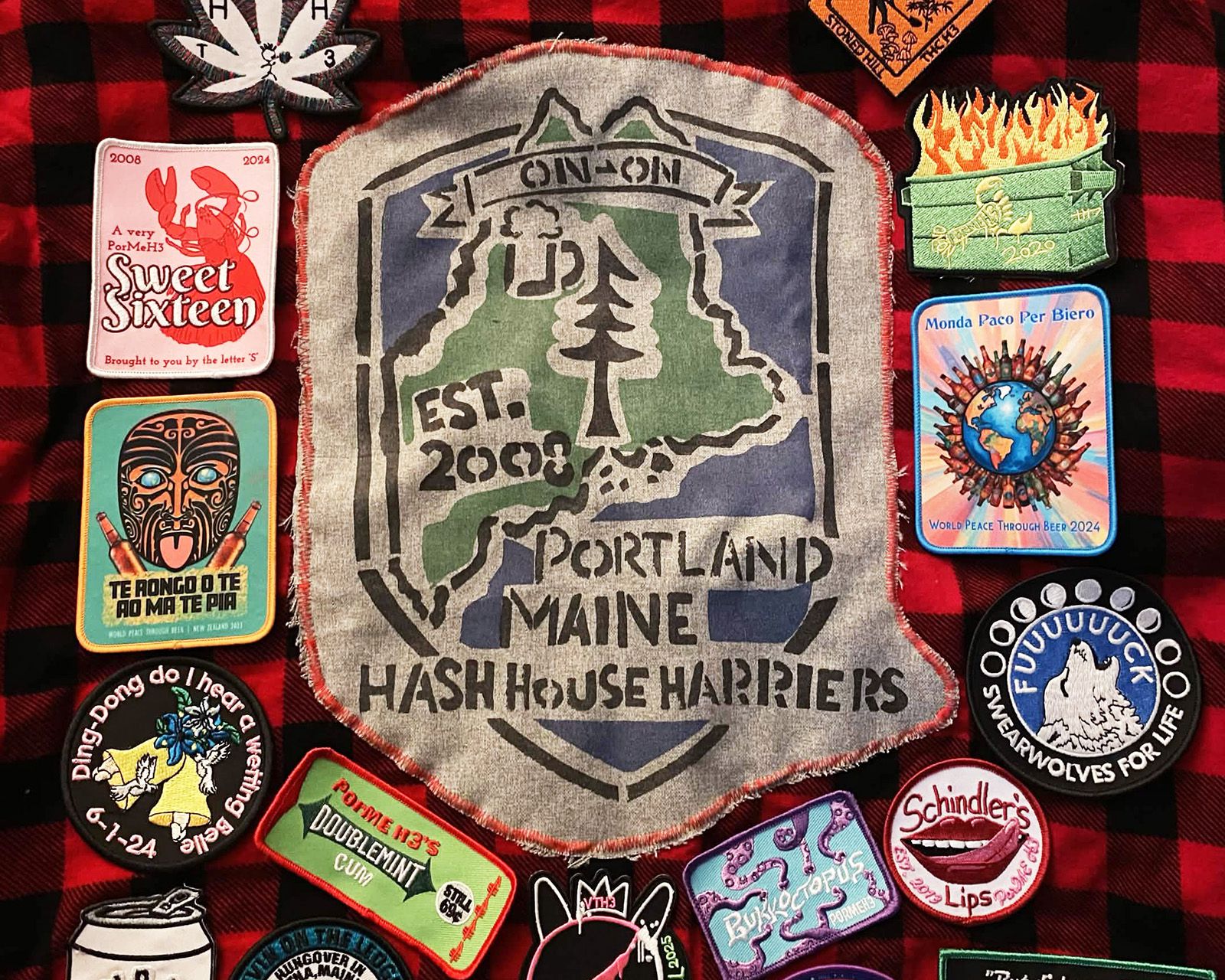 A Portland Maine Hash House Harriers patch sewn onto flannel among other hash patches
